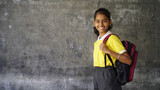 Portrait of happy indian teenager school girl with backpack holding books. Smiling young asian female kid looking at camera.