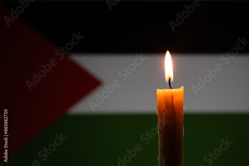 Mourning in country palestine, gaza strip. burning candle on the background of the palestinian flag. Victims of cataclysm or war concept. National mourning. war in Middle East