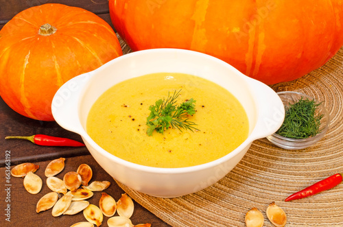 Pumpkin hot puree soup on a wooden table