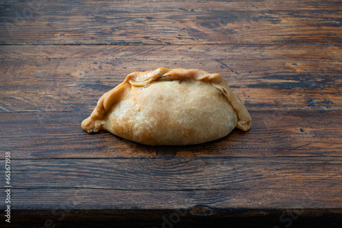 Closeup of a vegetable Cocarrois, on a brown wooden background.Typical empanadas from Mallorca