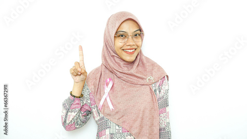 young asian woman patient showing pink badge ribbon chest to support breast cancer cause campaign.  photo
