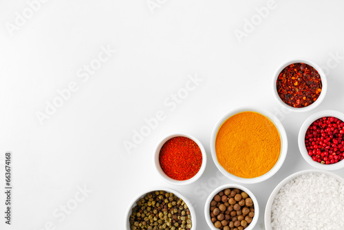 Various spices in a bowls on white background