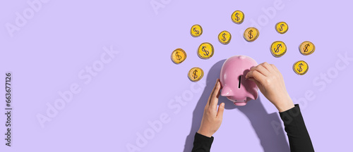 Person depositing money in a pink piggy bank