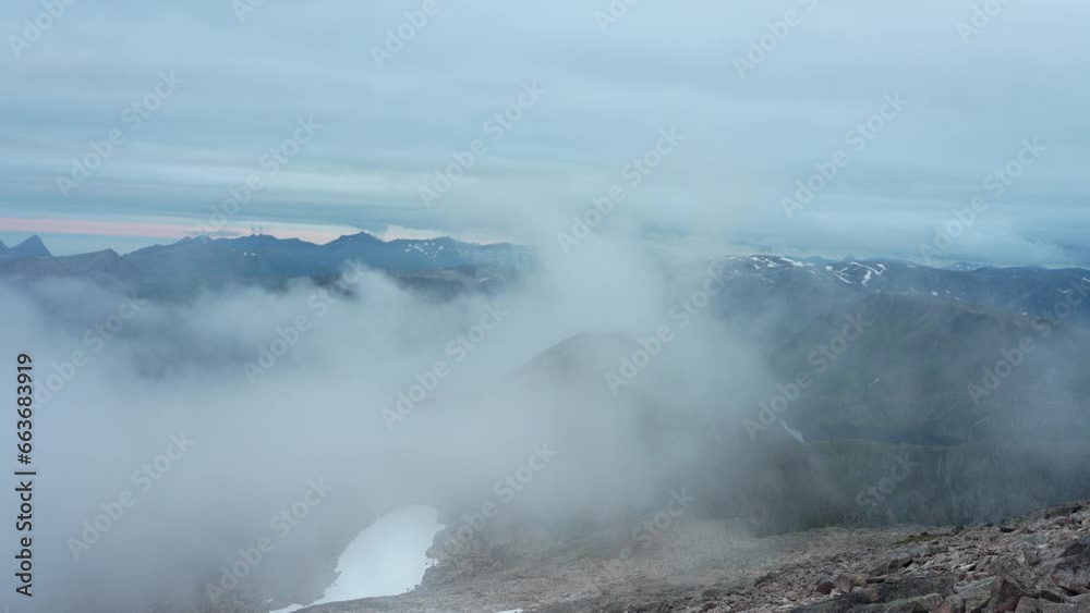 A Closeup View of Foggy Mountain Peak in Kvænan, Senja Island, Norway A Closeup View of Foggy Mountain Peak in Kvænan, Senja Island, Norway