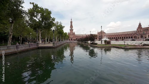 Pan shot of tourists boating in Plaza de Espana along Spanish Square in Sevilla, Spain on a cloudy evening. photo