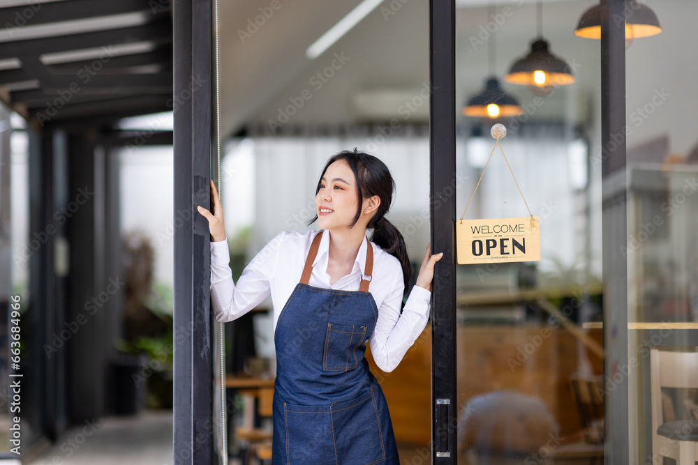 Fototapeta premium Startup successful small business owner sme beauty girl stand with tablet smartphone in coffee shop restaurant. Portrait of asian tan woman barista cafe owner. SME entrepreneur seller business concept