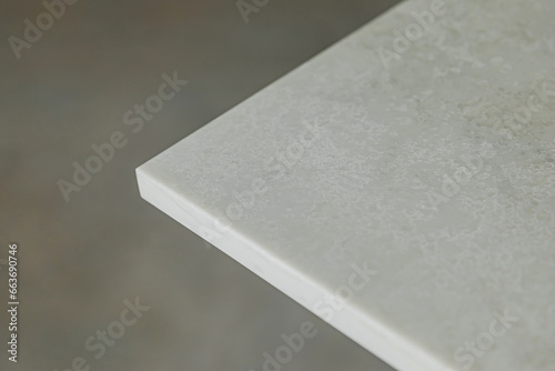 Close-up of a corner of light grey stone table top