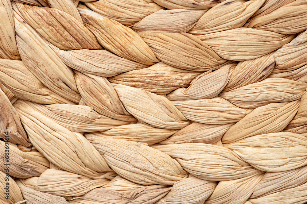 Texture of woven material in the form of a braid. Dry woven round napkin in close-up Texture of woven material in the form of a braid. Dry woven round napkin in close-up