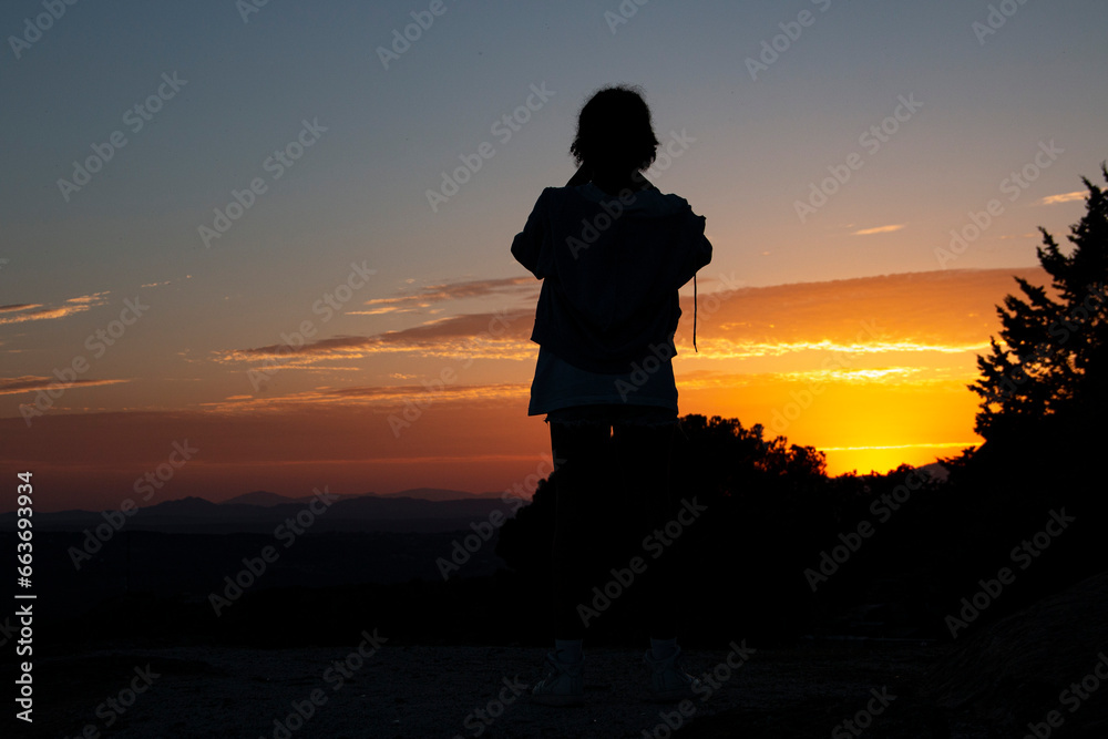 Silhouettes of a single-parent family on a sunset in the mountains
