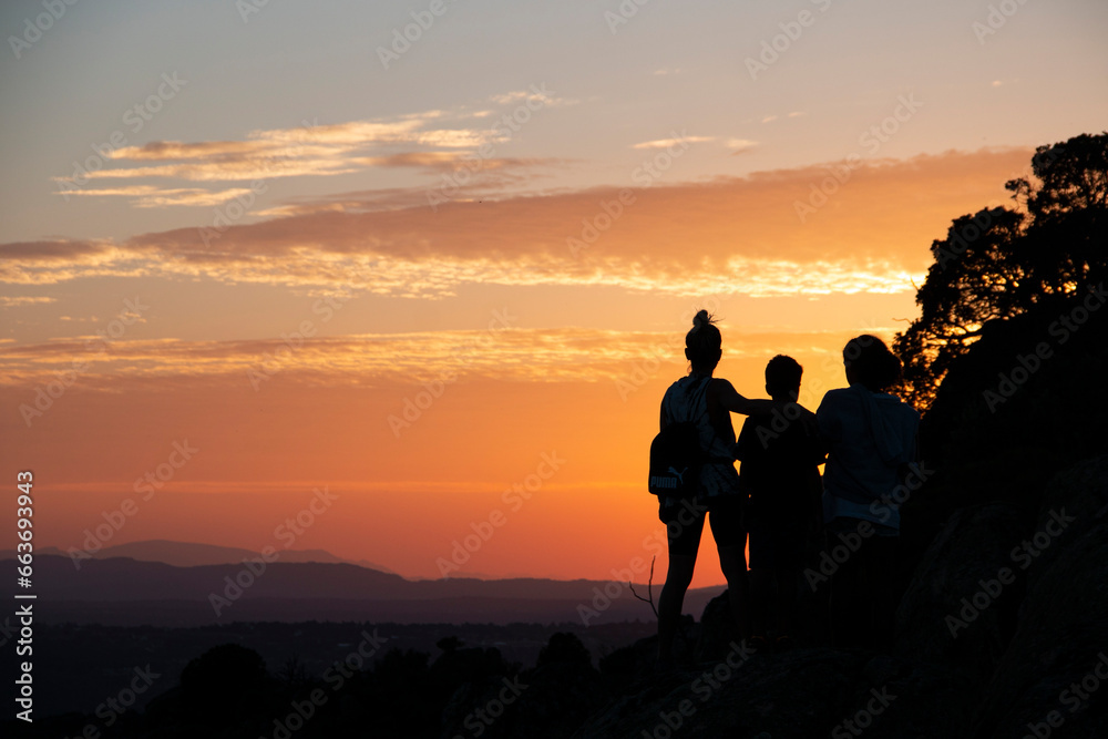 Silhouettes of a single-parent family on a sunset in the mountains