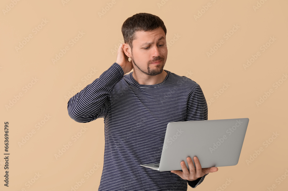Thoughtful man with laptop on beige background Thoughtful man with laptop on beige background