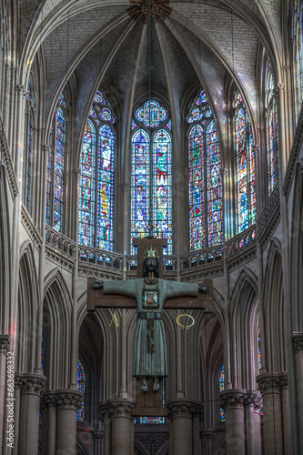 Interior of the cathedral Saint-Julien du Mans, cross of Jesus above the altar in front of the stained glass window