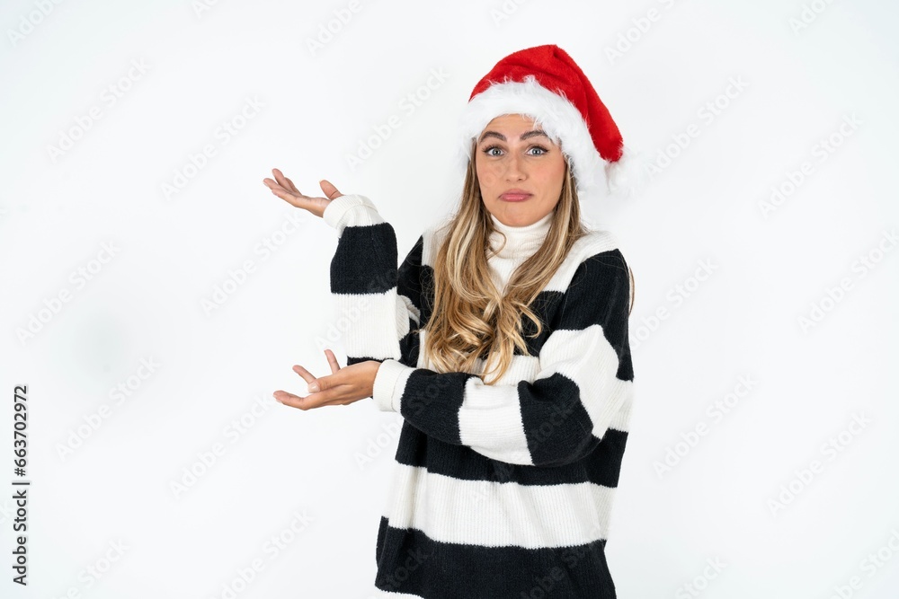 Young beautiful woman pointing aside with both hands showing something strange and saying: I don't know what is this. Advertisement concept. Young beautiful woman pointing aside with both hands showing something strange and saying: I don't know what is this. Advertisement concept.