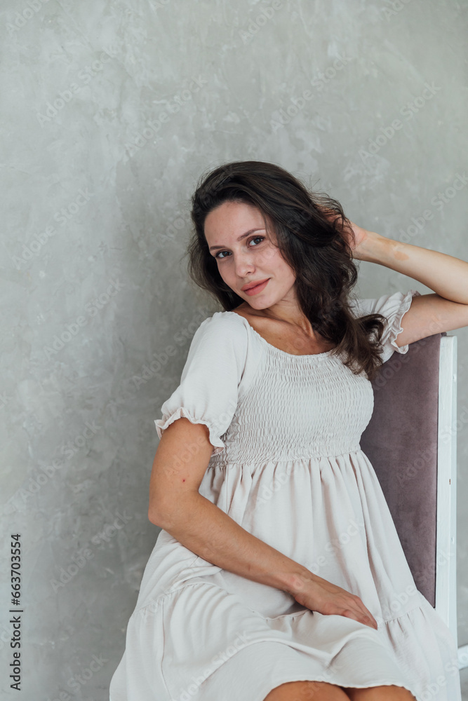 Woman in white dress sitting in bright room Woman in white dress sitting in bright room