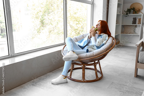 Young redhead woman eating ...