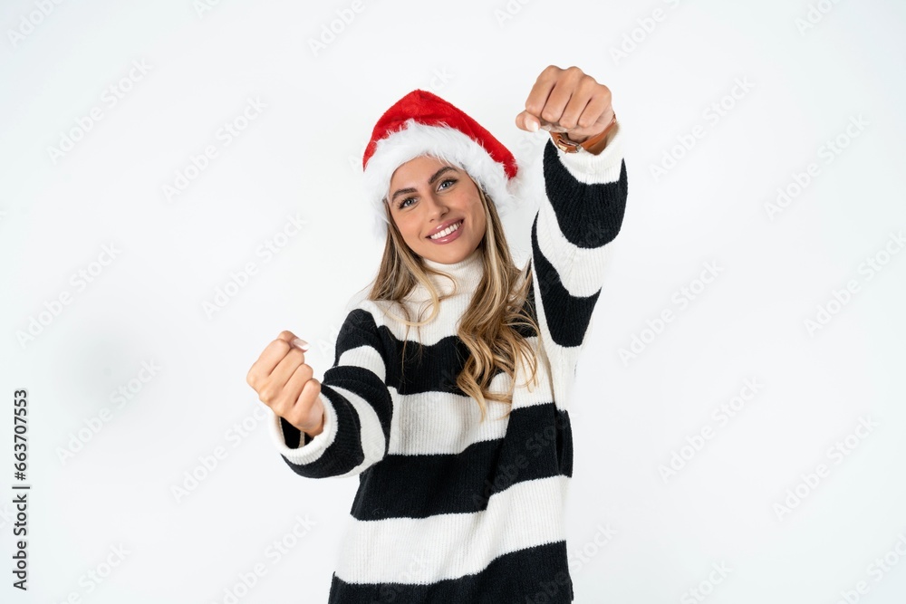 Beautiful hispanic woman wearing christmas hat and striped knitted sweater imagine steering wheel helm rudder passing driving exam good mood fast speed Beautiful hispanic woman wearing christmas hat and striped knitted sweater imagine steering wheel helm rudder passing driving exam good mood fast speed