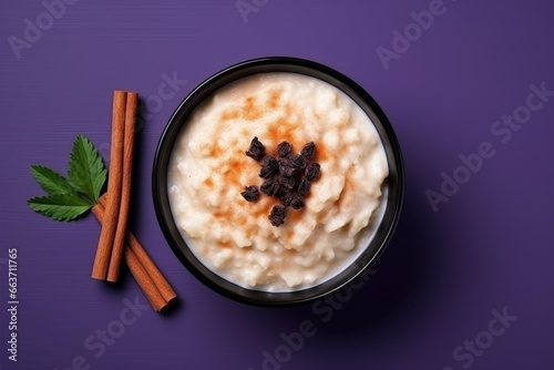  A Traditional Homemade Dessert - Creamy Rice Pudding with Cinnamon and Raisins, Served in a Bowl on a Lilac Background, Ready to Delight Your Taste Buds photo