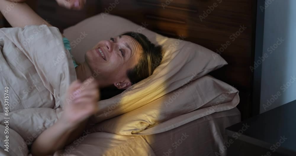 Happy joyful woman wakes up with first rays of sun in bed. Positive mood and healthy sleep concept Happy joyful woman wakes up with first rays of sun in bed. Positive mood and healthy sleep concept