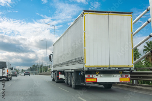 Truck transportation on the road on a highway bridge in the city on a nice clear summer day.