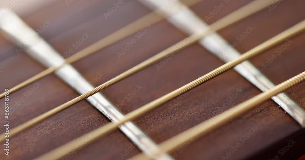 Closeup of wooden guitar strings 4k movie slow motion. Acoustic musical instruments concept Closeup of wooden guitar strings 4k movie slow motion. Acoustic musical instruments concept
