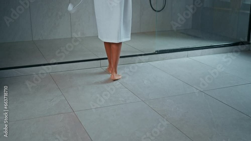 back view woman dressed white bathrobe walks to the shower cabin slow motion bathroom at home morning routine