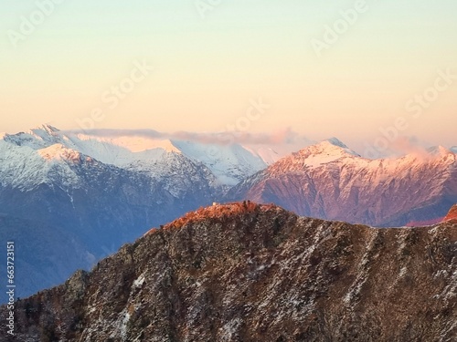 Snow-Capped Mountains with Green and Dry Grass, Clouds, and a Stunning Sky
