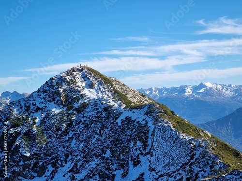 Snow-Capped Mountains with Green and Dry Grass, Clouds, and a Stunning Sky