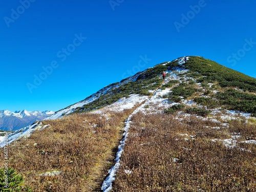Snow-Capped Mountains with Green and Dry Grass, Clouds, and a Stunning Sky