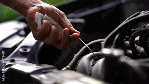 Drivers are Pulling the engine oil level dipstick To check the quality of engine oil. transportation concept