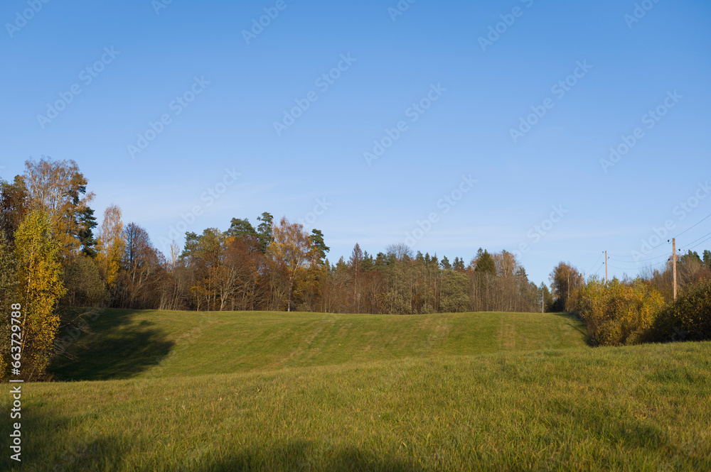Autumn rural landscape with rich autumn colors of fields and forest. October in countryside..