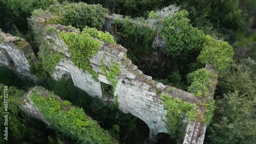 Closeup aerial orbit around monastery ruins overgrown with vegetation in Spain photo