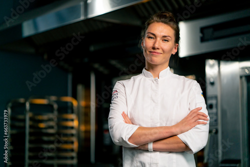 Fotografia Portrait of a smiling female chef baker in a professional uniform in a bakery ag