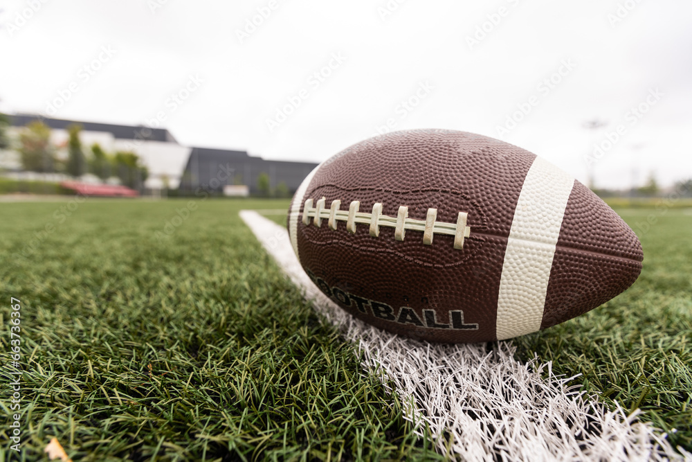 Close up view of an American Football sitting on a grass football field on the yard line. Generic Sports image Close up view of an American Football sitting on a grass football field on the yard line. Generic Sports image