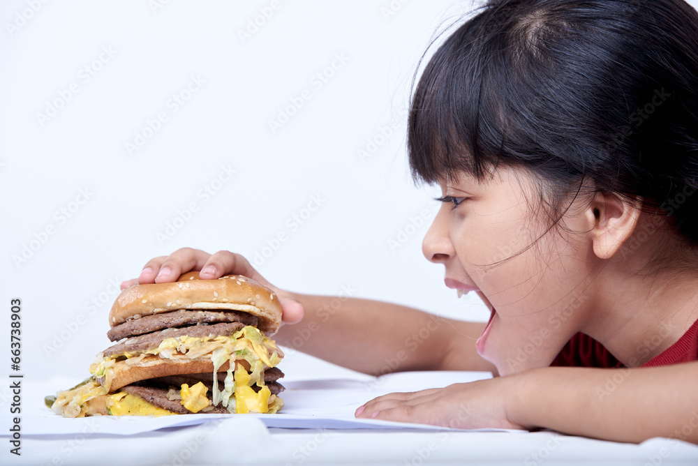Cute little girl eating an appetizing cheeseburger Cute little girl eating an appetizing cheeseburger