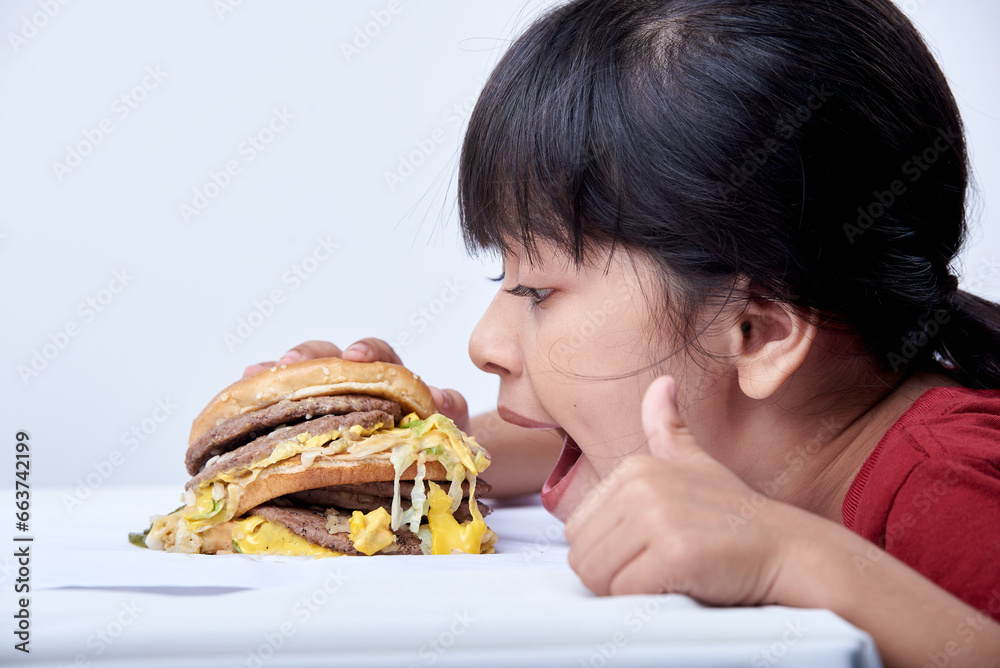 Cute little girl eating an appetizing cheeseburger Cute little girl eating an appetizing cheeseburger