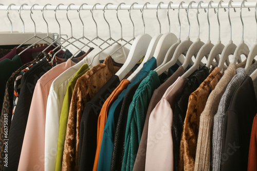 Women's fashion. Different clothes on hangers, close up. Huge selection of different used womens clothes on the rack in a second hand shop or thrift store. Concept of waste problem in fashion industry