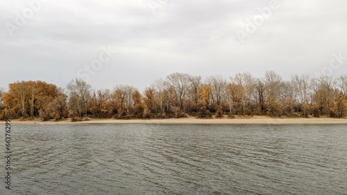 autumn landscape: trees along the shore on the other side of the river