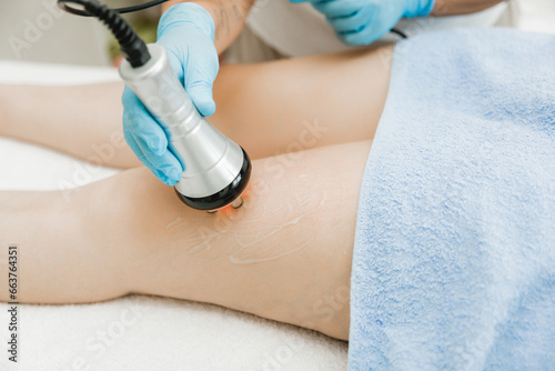 Foto cosmetologist performing ultrasonic cavitation procedure on a client