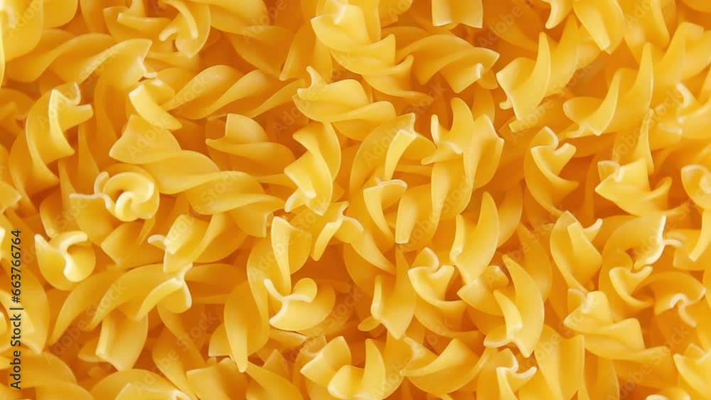 Uncooked Fusilli Pasta - Top View, Close-Up. Fat and Unhealthy Food. Dry Spiral Macaroni, Slowly Rotating Background. Italian Culture and Cuisine. Raw Golden Pasta Pattern. Right Rotation Uncooked Fusilli Pasta - Top View, Close-Up. Fat and Unhealthy Food. Dry Spiral Macaroni, Slowly Rotating Background. Italian Culture and Cuisine. Raw Golden Pasta Pattern. Right Rotation
