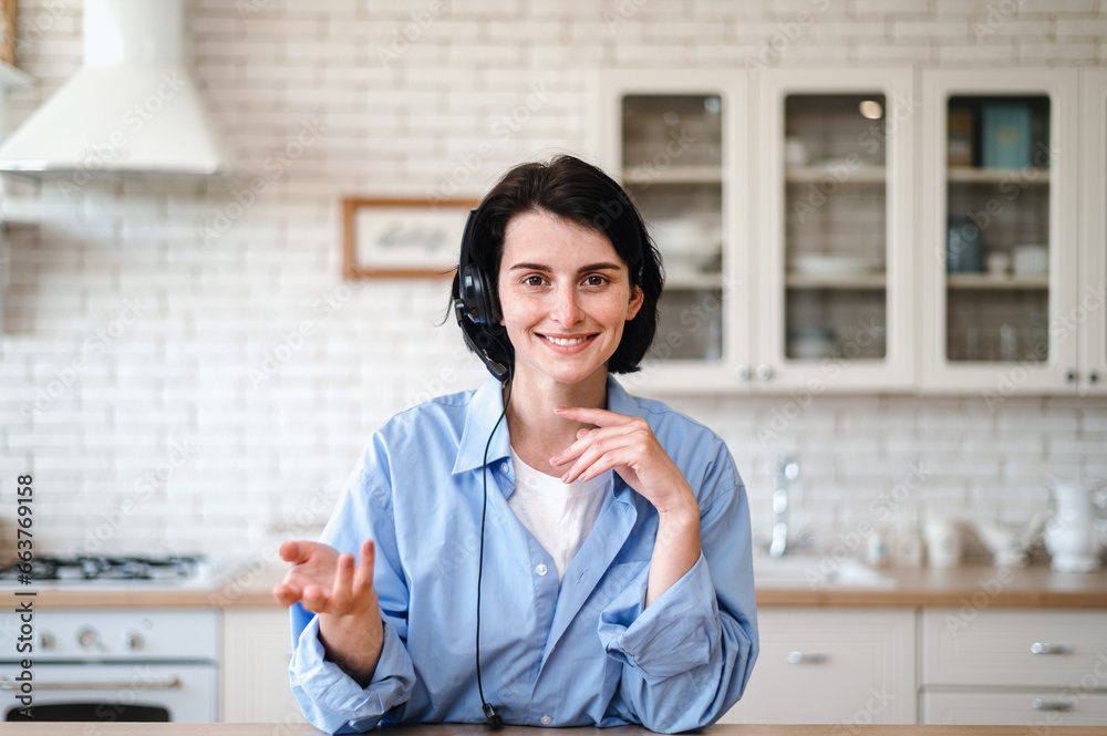 Smiling woman in headset talking with client by video call Smiling woman in headset talking with client by video call