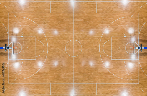 Top view of a parquet basketball court with hoops installed and reflections from lighting