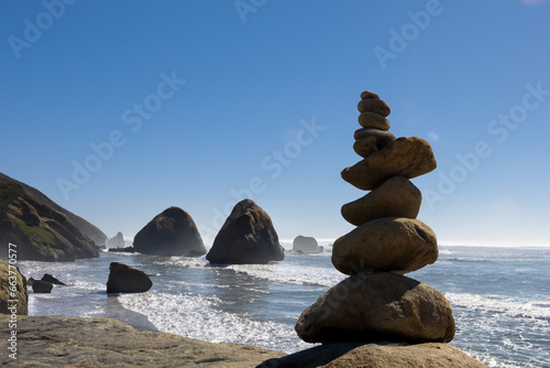 sandy beach with blue sea there are large pyramids of stones on the sand. AI GENERATE