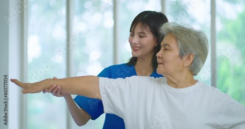 Beautiful asian nurse taking care of senior woman to exercise at hospital. She feeling happy when take care senior woman. Healthcare, Retirement, Volunteer, Caregiver and Lifestyle concept. photo