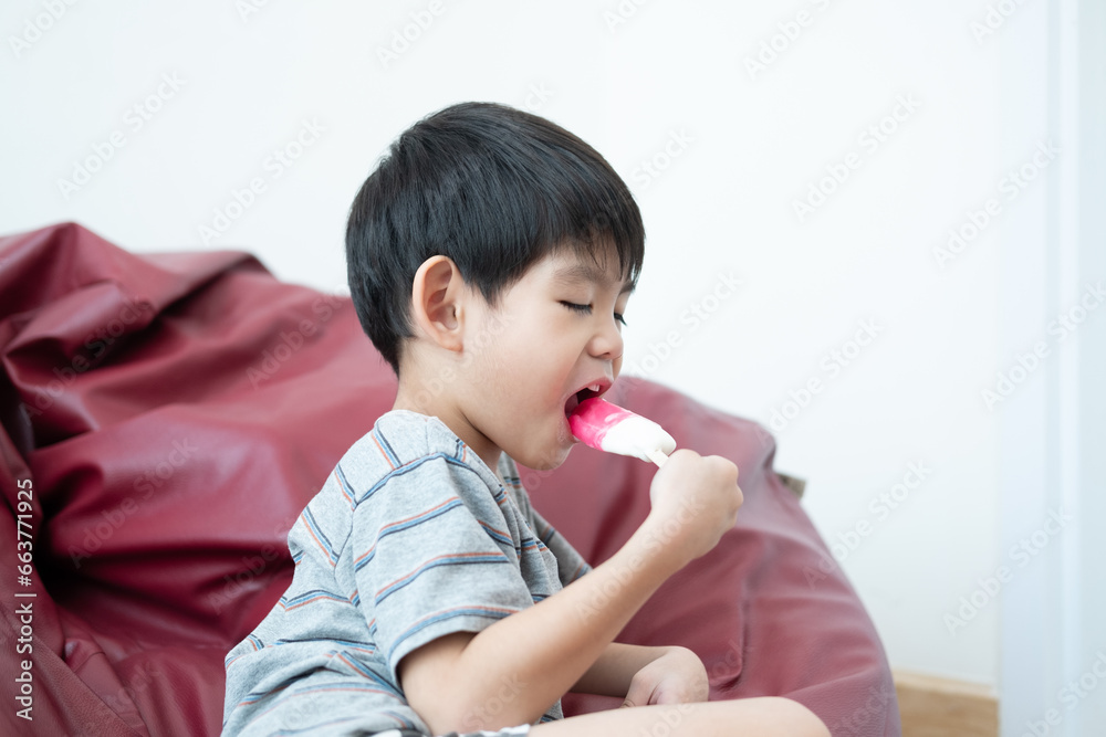 An Asian boy is eating delicious ice cream in a chair. An Asian boy is eating delicious ice cream in a chair.