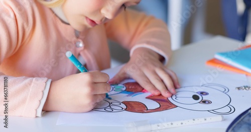 Girl child, drawing and color in classroom, learning and development with art, animal sketch or paper at desk. Female kid, writing and notebook for bear, education or pen for study, academy or school photo