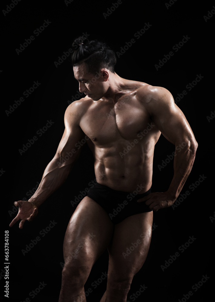 Strong, fit and sporty bodybuilder man over black background