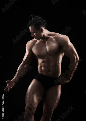 Strong, fit and sporty bodybuilder man over black background © chotiga