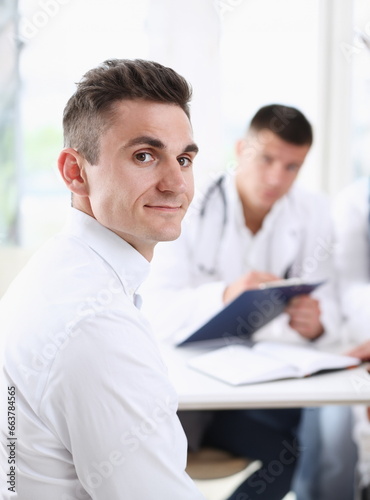 Satisfied happy handsome smiling male patient with doctor at his office. High level and quality medical service therapeutist consultation work and career physical healthy lifestyle concept