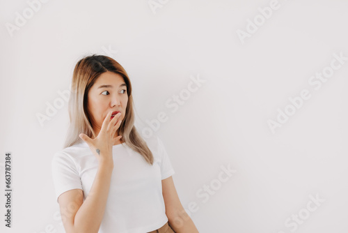 Asian Thai woman funny shocked face, surprised amazed, unbelievable with hand covering mouth while looking at camera, isolated on white background.