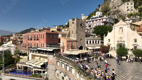 La Terrazza panoramica di Taormina affollata di turisti di tutto il mondo, Sicilia, sud Italia.
Ripresa aerea in 4k del centro storico in stile barocco costruito sulla montagna lavica dell'Etna.
 photo